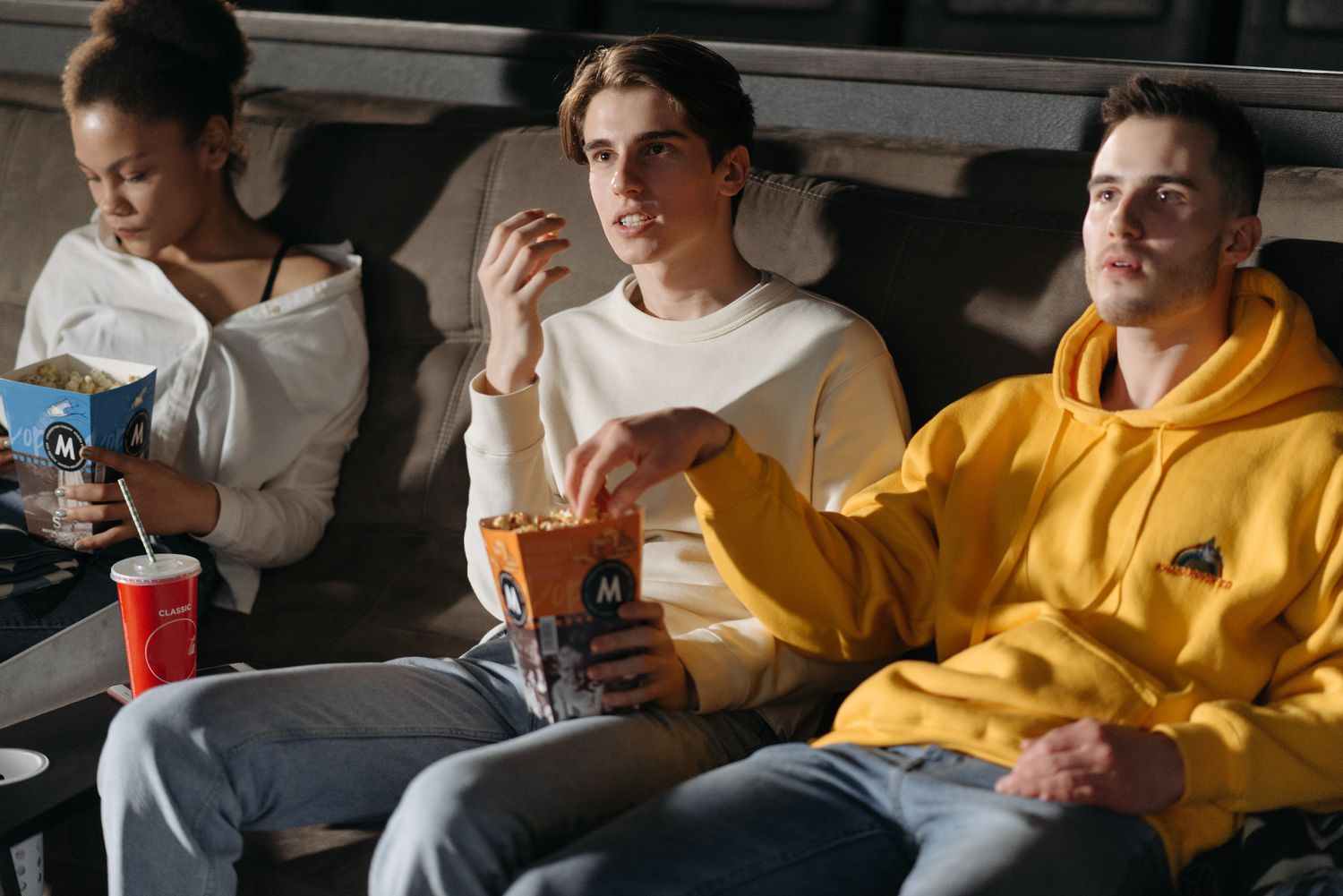 Drei Personen mit Popcorn bei einem gemeinsamen Filmabend.