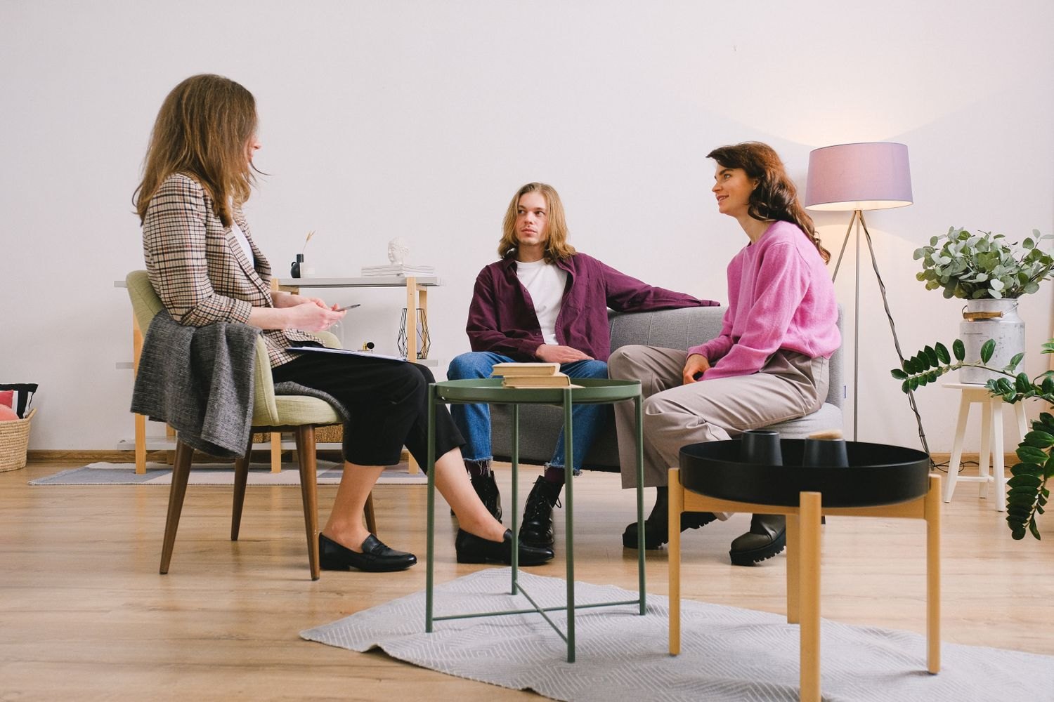 Three people in conversation in a living room.