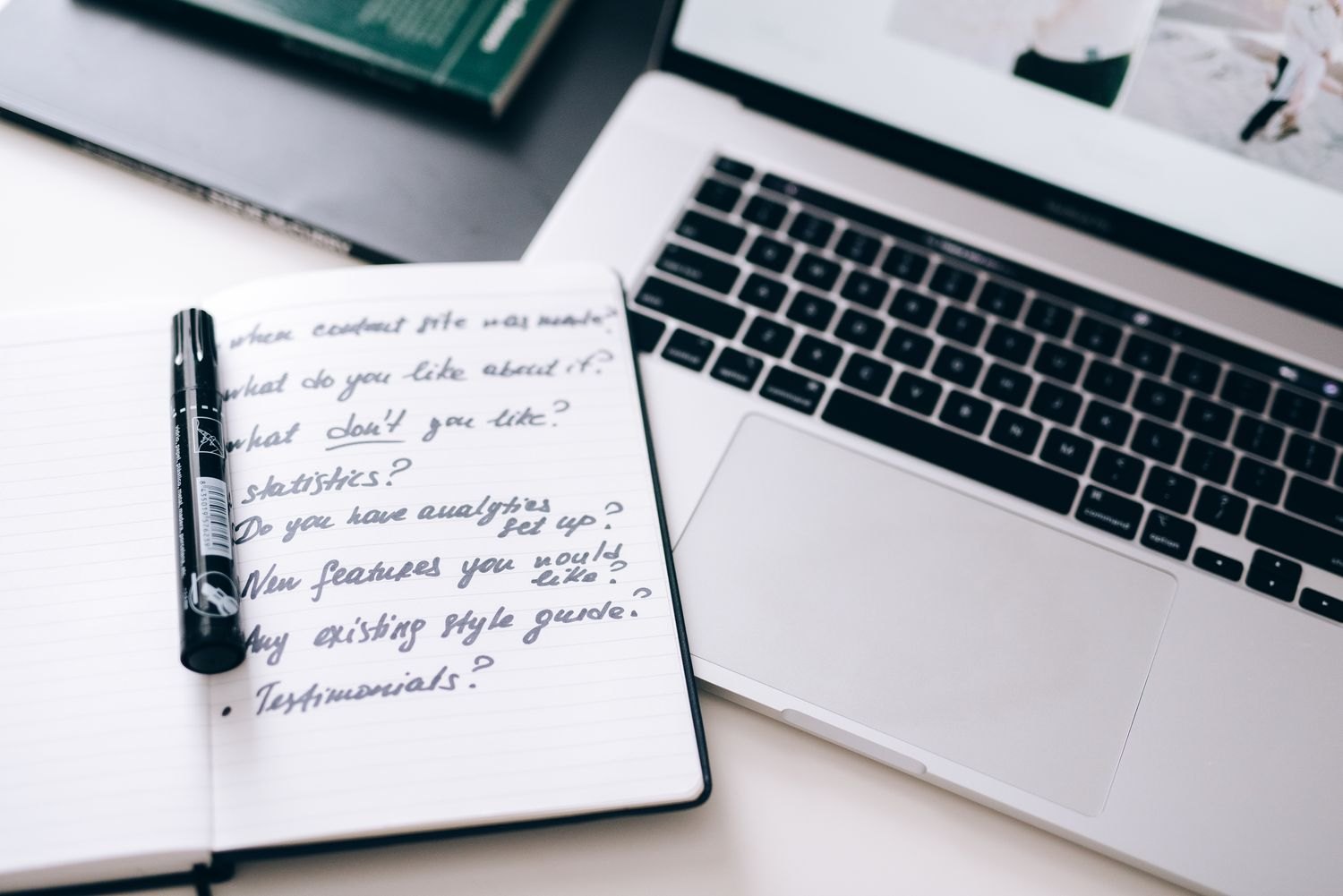 Handwritten notes beside a laptop as an example of comparison notes.