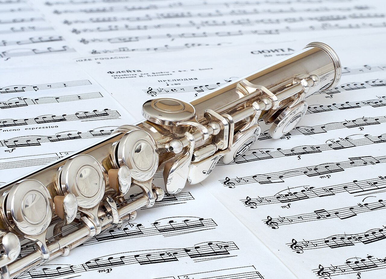 Querflöte auf Notenblättern als Beispiel eines Holzblasinstruments.