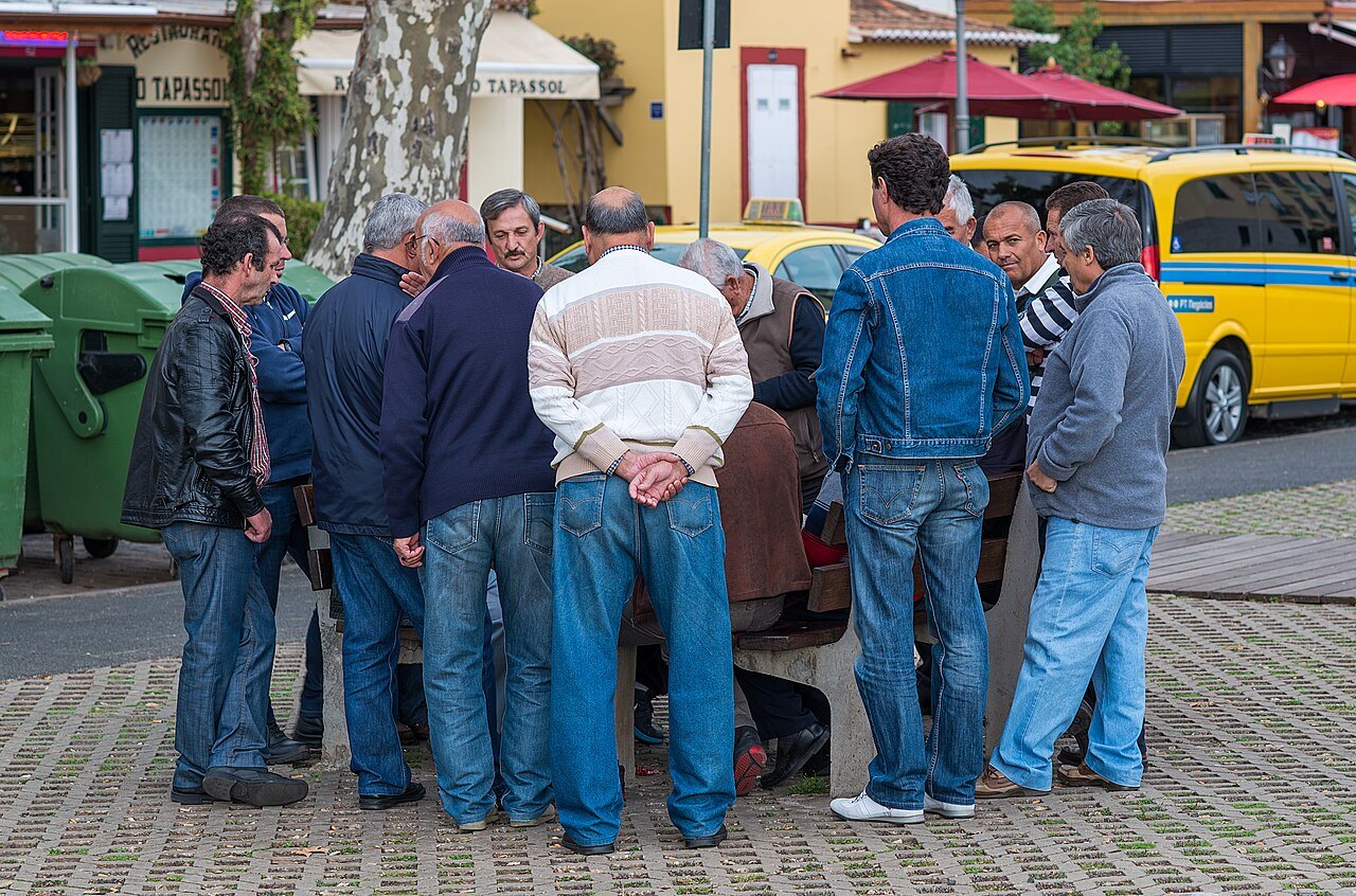 A group of people playing cards around a table.