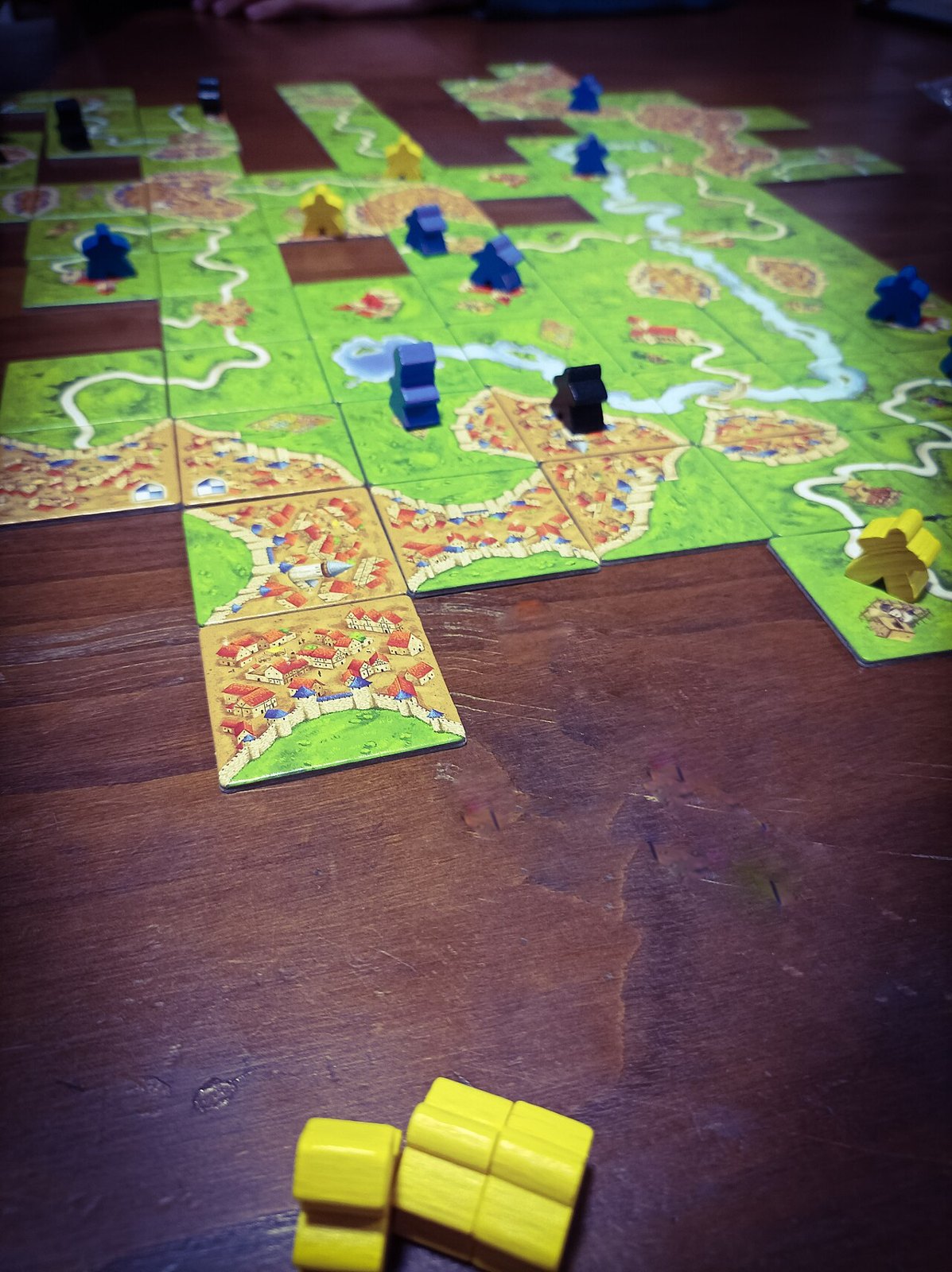 Connected landscape tiles and playing pieces in Carcassonne.