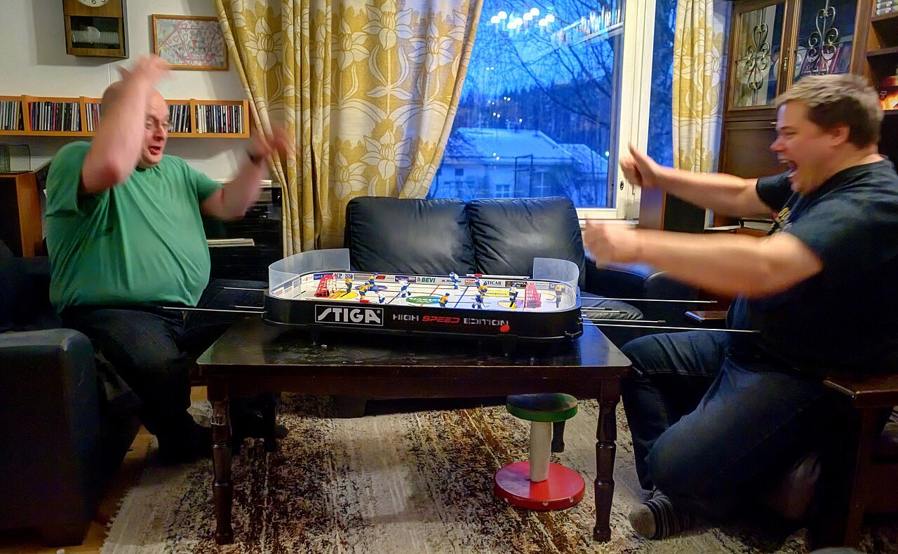 Two people playing table hockey.