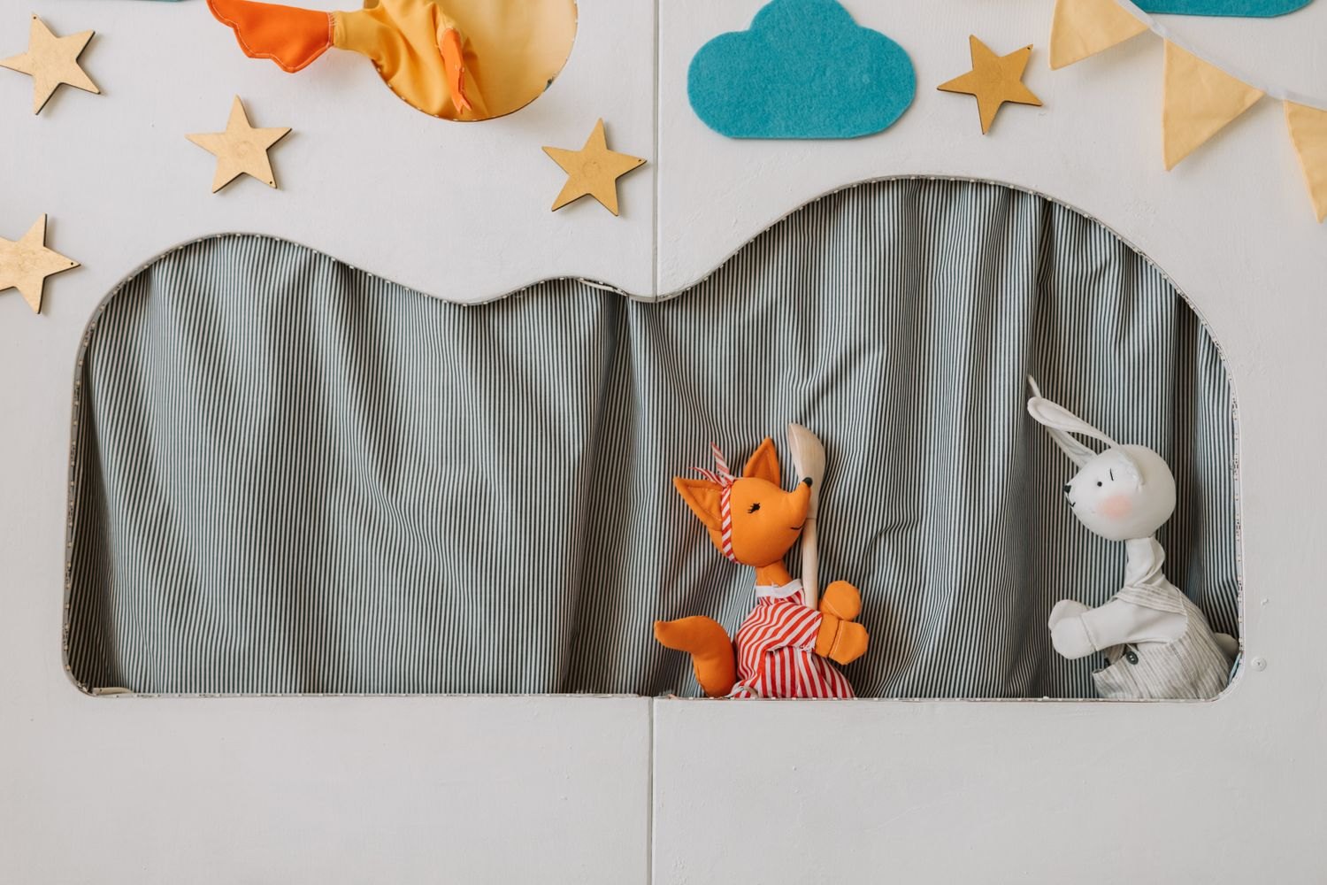 Two fabric characters on a small handmade puppet stage.